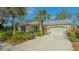 Inviting home featuring a manicured lawn, two-car garage, beautiful landscaping and a cheerful blue front door at 2377 Burton Ln, Sarasota, FL 34239