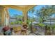Relaxing front porch featuring comfortable wicker furniture, iron railings, and views of the landscaped yard at 2377 Burton Ln, Sarasota, FL 34239