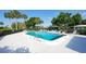 Community pool surrounded by lounge chairs and lush landscaping, creating a relaxing oasis at 3278 Village Green Dr # 1024, Sarasota, FL 34239