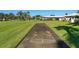 Community shuffleboard court set amidst beautifully landscaped grounds with lush green grass at 3278 Village Green Dr # 1024, Sarasota, FL 34239