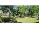 Lush backyard featuring mature trees and well-manicured lawn in a serene setting at 3370 E Chelmsford Ct # 49, Sarasota, FL 34235