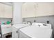 A clean and functional laundry room with white cabinets, a utility sink, and modern Samsung washer and dryer at 3370 E Chelmsford Ct # 49, Sarasota, FL 34235