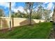 Manicured lawn and serene view of lush green backyard with a beige privacy wall at 3823 Parkridge Cir # 1-101, Sarasota, FL 34243