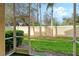 View of the screened-in patio with well-manicured backyard and tall palm trees at 3823 Parkridge Cir # 1-101, Sarasota, FL 34243