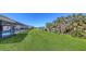 Green backyard with water view and screened in pool area at 3837 Torrey Pines Blvd, Sarasota, FL 34238