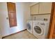 Laundry room with washer, dryer, cabinet storage and tile flooring at 3837 Torrey Pines Blvd, Sarasota, FL 34238