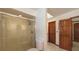 Shower featuring glass doors and a view of the wooden doors at 3837 Torrey Pines Blvd, Sarasota, FL 34238