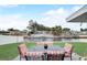 Backyard patio area with outdoor dining set overlooking the waterfront and a boat dock, perfect for enjoying waterfront living at 408 Bryn Mawr Is, Bradenton, FL 34207