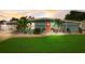 Charming single story home with bright blue paint, a front yard, and a coral front door at 408 Bryn Mawr Is, Bradenton, FL 34207