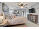 Comfortable bedroom features a ceiling fan, television, barn door to en-suite bathroom, and a beautiful, large bed at 408 Bryn Mawr Is, Bradenton, FL 34207