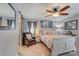 Bedroom features painted wood flooring, area rug, ceiling fan, comfy chair, and a king size bed; neutral walls and grey accents at 408 Bryn Mawr Is, Bradenton, FL 34207