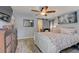 Bright bedroom features a large bed, ceiling fan, decorative mirror, and light neutral walls; wood floors add warmth at 408 Bryn Mawr Is, Bradenton, FL 34207