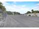 Spacious parking lot enclosed by a chain-link fence with trees in the background ensures secure parking facilities at 408 Bryn Mawr Is, Bradenton, FL 34207