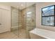 Elegant bathroom with glass enclosed shower, a soaking tub, and modern fixtures and neutral color palette at 428 Bocelli Dr, North Venice, FL 34275
