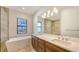 Luxurious bathroom featuring a soaking tub, walk-in shower, and double vanity with granite countertops at 428 Bocelli Dr, North Venice, FL 34275