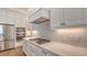 A modern kitchen shows white cabinetry, stainless steel appliances, and a tiled backsplash at 428 Bocelli Dr, North Venice, FL 34275