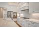 Well-lit kitchen featuring white cabinets, a range hood, subway tile backsplash, and stainless steel appliances at 428 Bocelli Dr, North Venice, FL 34275