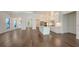 Spacious living room with hardwood floors and white trim open to kitchen with island at 428 Bocelli Dr, North Venice, FL 34275