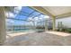 Relaxing screened-in pool area features a luxurious pool, spa, and travertine tile floors with a lake view at 428 Bocelli Dr, North Venice, FL 34275