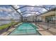 Clean in-ground pool and spa encased in a screened-in enclosure with a lake view at 428 Bocelli Dr, North Venice, FL 34275
