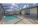 Sparkling in-ground pool and spa with an enclosed screen and travertine deck at 428 Bocelli Dr, North Venice, FL 34275