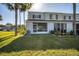 Exterior view of the back of the home featuring a lawn and tropical landscaping at 4717 Sabal Key Dr, Bradenton, FL 34203