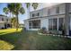 Backyard with a lush green lawn, screened-in patio, and tropical landscaping at 4717 Sabal Key Dr, Bradenton, FL 34203