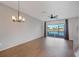 Spacious living room with wood floors, ceiling fan, and sliding glass doors to the lanai at 4717 Sabal Key Dr, Bradenton, FL 34203
