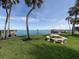 Scenic waterfront picnic area featuring a stone picnic table and manicured lawn at 4822 Ocean Blvd # 2D, Sarasota, FL 34242