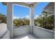 Balcony view with gray railings, and the scene features lush tropical trees and clear skies above at 501 Reclinata Dr, Longboat Key, FL 34228