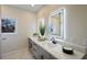 Bathroom with dual sinks, LED mirrors, white countertops, and gray cabinetry at 501 Reclinata Dr, Longboat Key, FL 34228