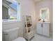 Clean bathroom featuring a lighted mirror, modern sink, white marble floors, and a decorative ladder shelf at 501 Reclinata Dr, Longboat Key, FL 34228