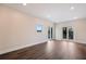 Large room with wood floors, recessed lighting, French doors to a balcony, and a window at 501 Reclinata Dr, Longboat Key, FL 34228