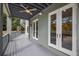 View of a covered patio with a ceiling fan, French doors, and views of a pool at 501 Reclinata Dr, Longboat Key, FL 34228