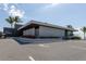 Contemporary building with a minimalist design, featuring clean lines, palm trees and manicured landscaping at 501 Reclinata Dr, Longboat Key, FL 34228