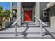 Close-up of the home's welcoming red front door and covered porch at 501 Reclinata Dr, Longboat Key, FL 34228