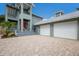 Close-up of home's two-car garage with a brick paver driveway at 501 Reclinata Dr, Longboat Key, FL 34228