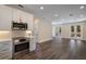 Bright kitchen featuring modern stainless steel appliances, white cabinetry, and dark wood flooring at 501 Reclinata Dr, Longboat Key, FL 34228