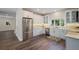 Modern kitchen boasts stainless steel appliances, white cabinetry, and hardwood flooring at 501 Reclinata Dr, Longboat Key, FL 34228