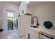 Modern laundry room features white cabinetry, countertops, stainless steel sink and modern washer and dryer at 501 Reclinata Dr, Longboat Key, FL 34228