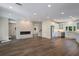 Open-concept space with a modern fireplace, hardwood floors, and a kitchen with stainless steel appliances at 501 Reclinata Dr, Longboat Key, FL 34228