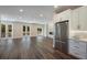 Open-concept living area featuring hardwood floors, a modern fireplace, and stainless steel kitchen appliances at 501 Reclinata Dr, Longboat Key, FL 34228