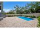 Backyard oasis featuring a sparkling pool, brick pavers, wood fence, and surrounding greenery at 501 Reclinata Dr, Longboat Key, FL 34228