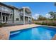 The backyard features a refreshing pool, brick paver patio, a wooden fence, and a two-story home with balconies at 501 Reclinata Dr, Longboat Key, FL 34228