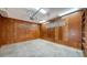 Spacious garage with wood paneling and a concrete floor with overhead lighting at 5011 Windsor Park, Sarasota, FL 34235