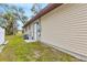 Side view of home with a small lawn and an entrance door at 5470 Ansonia Ter, North Port, FL 34287