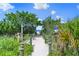 Wood and rope beach access walk way with tropical landscaping, dunes, and gulf views at 5556 Cantucci St, Nokomis, FL 34275