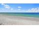 Scenic beach with light sand, blue ocean, and a partly cloudy sky at 5556 Cantucci St, Nokomis, FL 34275