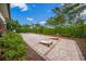 Outdoor cornhole area surrounded by lush landscaping and brick pavers at 5556 Cantucci St, Nokomis, FL 34275