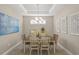 Charming dining room features a stylish chandelier, elegant artwork, and seating for six at 5556 Cantucci St, Nokomis, FL 34275